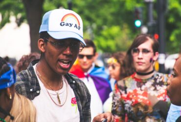 Personnes réunies autour d’un symbole arc-en-ciel